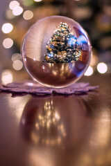 Decorated Christmas tree in glass ball. Selective focus. Holiday season background. Soft tone