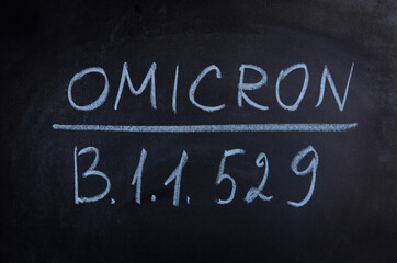 Obraz premium New variant of the Covid-19 Omicron B.1.1.529 medical banner, mixed media. New strain of coronavirus. Black school board and chalk text.