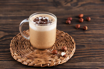 Mochaccino coffee with chocolate and coconut milk in a mug on a brown wooden table.