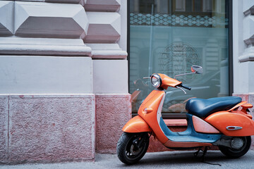 Motorbike outdoor. Orange retro style scooter on city street.