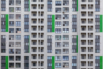 Background image - a white wall of a multi-storey building with green accents