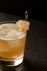 Author's ginger cocktail with foam. Party aesthetics. Festive drink. Cocktail close-up on a black background. Iced drink