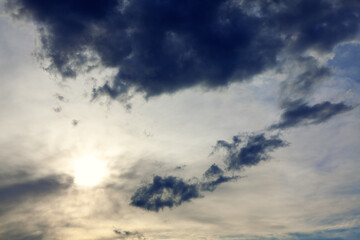 Sun glowing in grey clouds . Black and grey clouds with sunset 