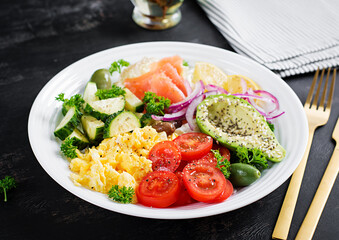 Salt salmon salad with tomatoes, cucumbers, scrambled eggs and avocado. Ketogenic diet breakfast. Keto lunch.