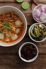 Local northern Thai food Egg noodle curry with meatballs on wood background