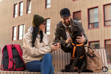 Our puppy. Happy young couple in love standing outdoors with their cute Labrador dog while walking at the autumn street