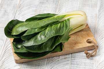 Whole swiss chard on wooden board: leafy green high-fiber vegetables, among the most nutrient-dense...