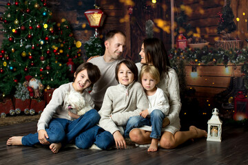Happy family with children and pet dog, enjoying Christmas time together, celebrating