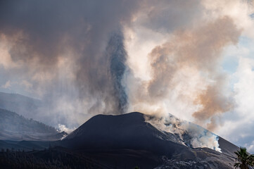 Active volcano with thick smoke erupting in daytime