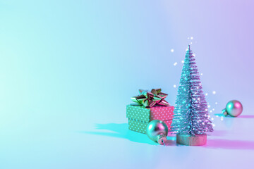 Neon Christmas winter background. Minimal abstract tree, xmas gift box. Holiday decoration bauble ball on neon gradient backdrop. Happy new year copy space.