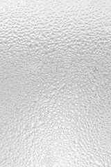 vertical abstract background of glass and raindrops on it. Black and white, monochrome background with water drops on the glass. Ribbed glass surface, vertical abstract background.