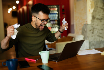 Angy businessman using laptop in his office. Tired man working in the office