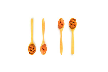 The almonds are in a brown wooden spoon on a white background.