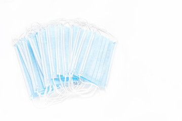 Fototapeta na wymiar Medical disposable masks on a white background. Several medical masks lie on a white surface, flat lay, copyspace, top view