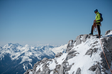 Fototapeta na wymiar Junger Bergsteiger mit Kletterausrüstung im Schnee am Dachsteingletscher