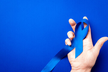 Prostate care. Awareness prostate cancer of men health in November. Blue ribbon in hands isolated...