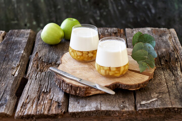 Panna cotta with apple layer. Side view, wooden background.	
