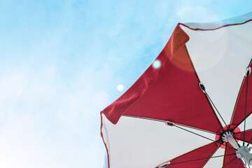 Umbrella beach. Red summer beach parasol on blue sea background. Sun sunshade for vacation travel....