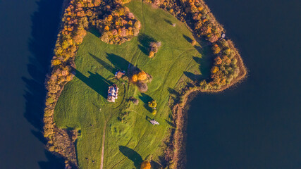 Old ruined church with grass on the roof and bell tower on island. Aerial view of old church ruins.