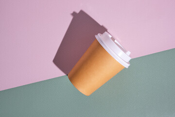 Paper disposable cup for hot coffee and tea on a pink green background.Concept and trend of takeaway food.