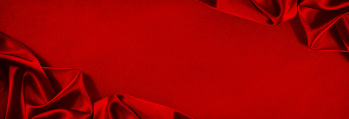 Beautiful red silk satin background. Soft folds on shiny fabric. Luxury background with copy space...