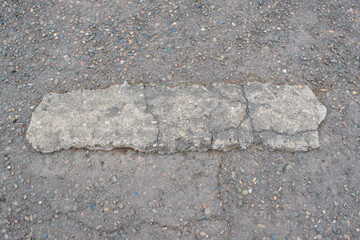 Concrete stone on asphalt surface.