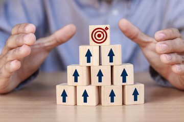 wooden cube with an arrow pointing to the target icon. Growing business success concept