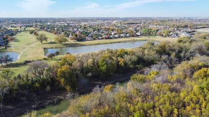 Fototapeta na wymiar Top view country club golf course and lakeside residential houses near nature park with fall foliage in Carrollton, Texas, USA