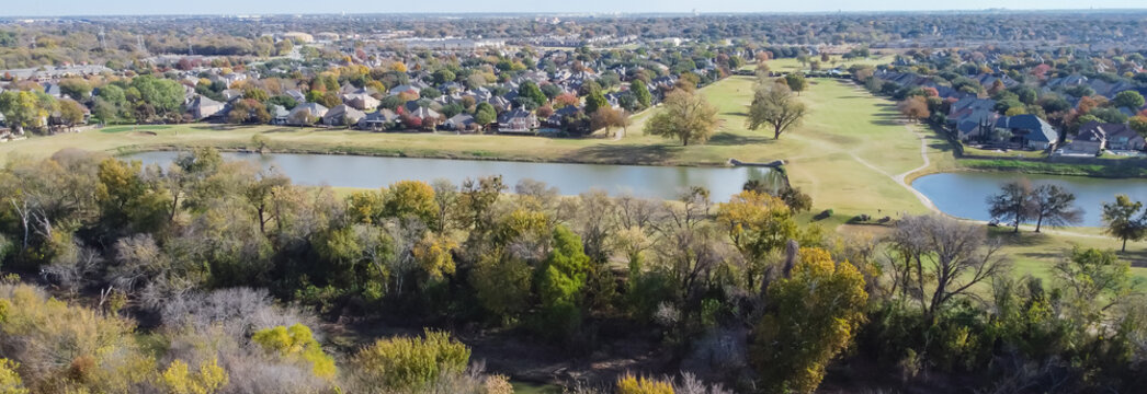 Panoramic top view country club golf course and lakeside residential houses near nature park with fall foliage in Carrollton, Texas, USA