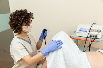 Physiotherapist holding radiofrequency machine for treatment of stimulation of the cells