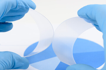 Scientist hold and bend two pieces of flexible transparent plastic like polymer material in...