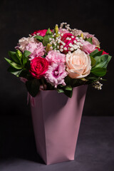 A bouquet of flowers in a box. Gift pink box with flowers on a black background.