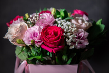 Beautiful bouquet of colorful rose flowers on a black background. Festive flowers concept with copy space. Flowers on a black background. Bouquet of fresh roses, freesias, eustoma and others.