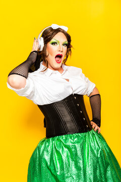 Man With Make-up Of Drag Queen Dancing And Shouting Against Yellow Background