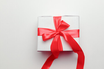 White gift box with red ribbon, isolated on white background