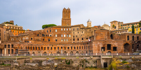 Fototapeta na wymiar Ancient ruins in front of newer buildings in Rome, Italy