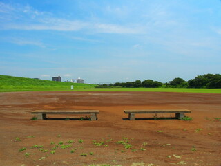 Obraz premium 梅雨晴れの平日の河川敷の整地された野球場風景