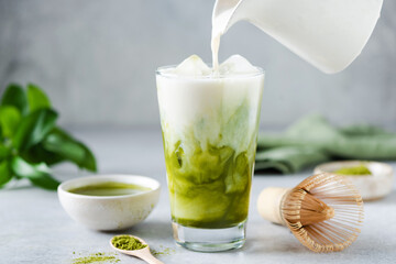 Soy milk pouring in matcha ice tea. Healthy vegan drink - 472213100