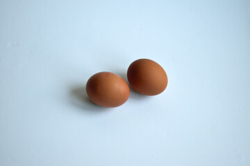 two brown chicken eggs on a white background