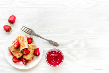 Hot rolled pancakes with strawberry and berry sauce