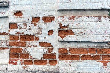the texture of the red brick wall covered with whitewash