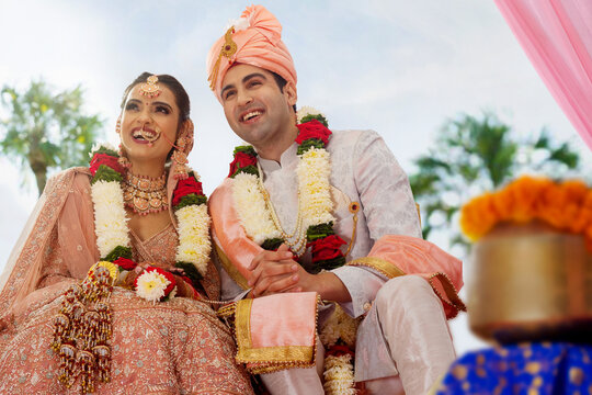 The bride and groom sitting together at wedding mandap