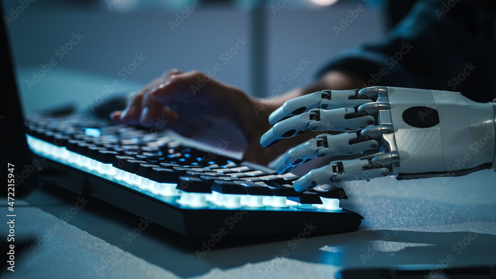 Fototapete Close-up on Hands: Programmer With Disability Using Prosthetic Arm to Work on Backlit Computer Keyboard. Specialist Swift and Natural Use of Myoelectric Bionic Hand To Type for e-Commerce Software