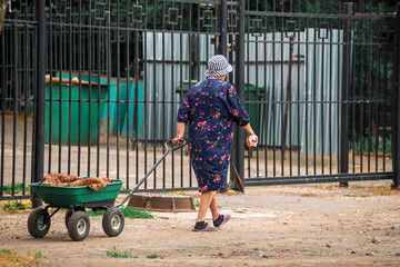 an elderly woman with a garden cart