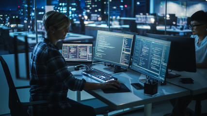 Night Office: Programmer With Disability Using Prosthetic Arm to Work on Computer Keyboard. Swift...