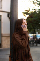 Fototapeta premium Girl calling with her phone in the street