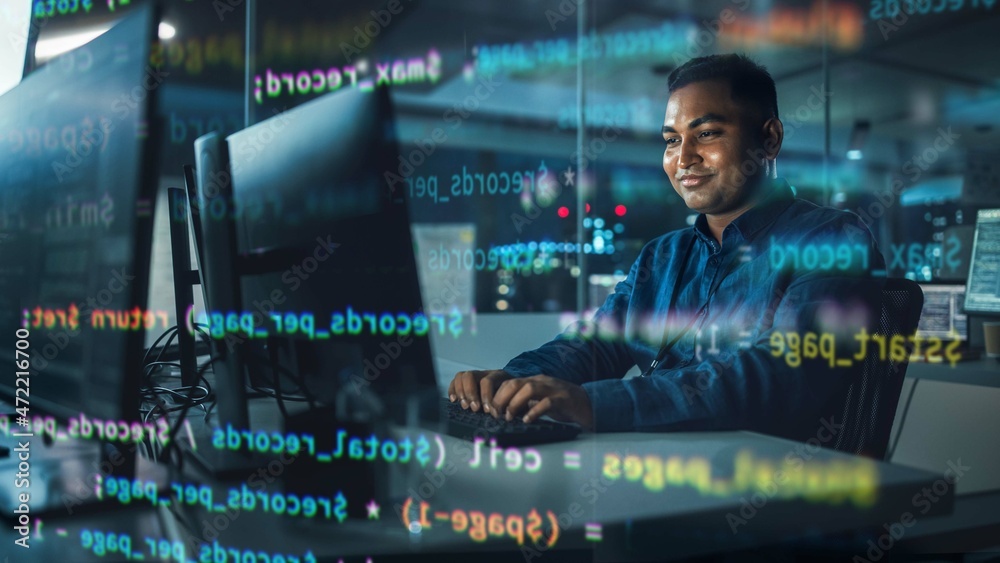 Poster Concept Shot with Visualisation of Running Computer Code on Foreground. Portrait of Handsome Indian Man in Working on Computer at Night in Office. Digital Entrepreneur Creating Modern Software.