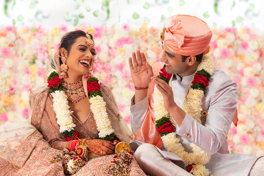 Portrait of a happy Indian wedding couple sitting together on mandap