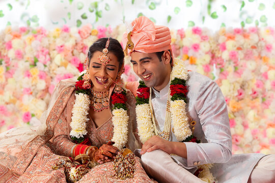 Portrait of a happy Indian wedding couple sitting together on mandap