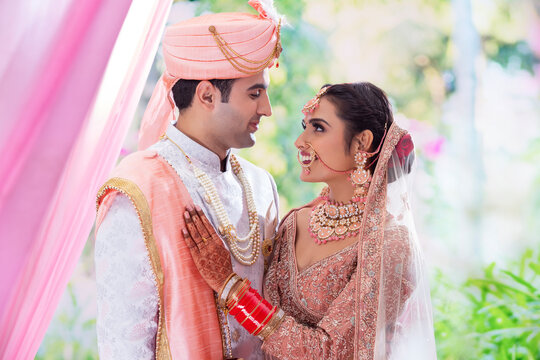 Portrait of an Indian wedding couple posing in front of camera for  photo album